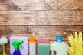 Bottles with detergents, brushes and sponges on wooden background. Colorful cleaning products. Home cleaning concept. Top view, Royalty Free Stock Photo