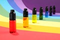 Bottles with different food coloring on rainbow background Royalty Free Stock Photo