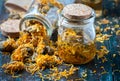 Bottles and dried calendula officinalis petals with macerated oil on wooden background. Royalty Free Stock Photo