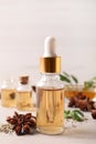 Bottles of essential oil, anise and seeds on white wooden table Royalty Free Stock Photo