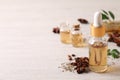 Bottles of essential oil, anise and seeds on white wooden table. Space for text Royalty Free Stock Photo