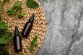 Bottles of essential oil and mint on grey table, top view. Space for text Royalty Free Stock Photo