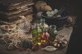 Bottles of essential oil, mortar of dried moss, old books, dry roots and plants.