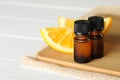 Bottles of essential oil and orange slices on white wooden table, closeup. Space for text Royalty Free Stock Photo