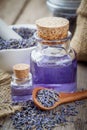 Bottles of essential oil, wooden spoon with dry lavender flowers Royalty Free Stock Photo