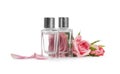 Bottles of essential oils and roses on white background Royalty Free Stock Photo