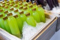 Bottles of fresh juice in a wooden bucket filled with ice Royalty Free Stock Photo