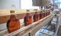 Bottles of fresh maple syrup on the production line at Ben`s Sugar Shack in Temple, N.H., USA, March 24, 2018. Royalty Free Stock Photo