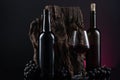 Bottles, glass of Spanish red wine and grapes on  wooden base on black and red background Royalty Free Stock Photo