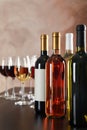 Bottles and glasses with wine against brown background Royalty Free Stock Photo