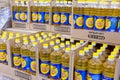 Bottles of Golden Seed sunflower oil stand in crates, ready for sale in a large supermarket.