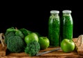 Bottles of green smoothie with ingredients on black background. Alkaline diet concept. Copy space Royalty Free Stock Photo