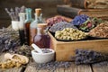 Bottles of healthy tincture or infusion, mortar and bowls of medicinal herbs in wooden crate, old books. Herbal