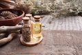 Bottles with herbs, dry flowers, stones and magic objects on witch wooden table.