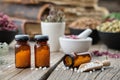 Bottles of homeopathic globules, books, mortars and bowls of healing herbs on background. Homeopathy Royalty Free Stock Photo