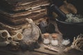 Bottles of homeopathic globules, mortar of dried moss, old books, dry roots, nuts and plants. Royalty Free Stock Photo