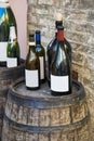 Bottles of Italian wine over wooden barrel. Royalty Free Stock Photo