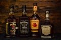 Bottles of Jack Daniels, Four Roses, Jim Beam, Jack Daniels Single Barrel premium American whiskey on a dark wooden