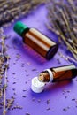 Bottles of lavandula essential oil, bunch of dried purple lavender blossom