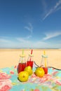 Bottles lemonade and fruit at beach Royalty Free Stock Photo