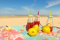 Bottles lemonade and fruit at beach Royalty Free Stock Photo