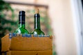 Bottles of liquor alcohol in a cardboard box getting home delivered online kept in the garden at the threshold of a home