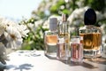 Bottles with luxury perfumes on table in garden