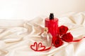 Bottles of male and female perfume, red roses, decorative hearts on the satin fabric background. Cosmetics Royalty Free Stock Photo