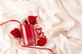 Bottles of male and female perfume, red roses, decorative hearts on the satin fabric background. Cosmetics Royalty Free Stock Photo