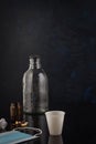 Bottles with medicines in a row on a black glass, pills, a medical mask, a measuring glass Royalty Free Stock Photo