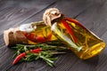 Bottles with oil, herbs and spices at wooden table on black back Royalty Free Stock Photo