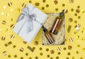 Bottles with oils or face serum in an open gift box on a yellow celebration background