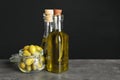 Bottles with olive oil on table against dark background Royalty Free Stock Photo