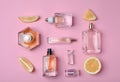 Bottles of perfume and lemon on color background