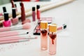 Bottles of perfume, makeup brushes and cosmetic products on table Royalty Free Stock Photo