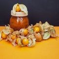 Bottles with physalis jam  and fresh  fruit  on orange Royalty Free Stock Photo