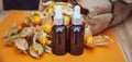 Bottles with physalis oil  and fresh  fruit  on orange Royalty Free Stock Photo