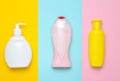 Bottles products for shower and bathroom on a multi-colored pastel background. Shampoo, liquid soap, shower gel. Top view.