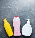 Bottles of products for showering on a black concrete surface.