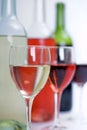 Bottles of red, white and rose wine with glasses fading into the distance Royalty Free Stock Photo