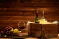 Bottles of red and white wine, glass and grape on a wooden inter Royalty Free Stock Photo