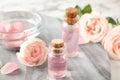 Bottles with rose essential oil and flowers Royalty Free Stock Photo