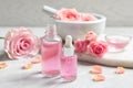 Bottles of rose essential oil and fresh flowers Royalty Free Stock Photo