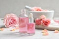 Bottles of rose essential oil and fresh flowers Royalty Free Stock Photo