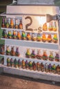 Bottles with sand shapes on shelves, simple pieces handmade. Local souvenirs with price. No copyright