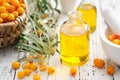 Bottles of sea buckthorn essential oil, mortar and basket of sandthorn berries Royalty Free Stock Photo