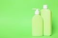Bottles of shampoo on green background. Natural cosmetic products Royalty Free Stock Photo