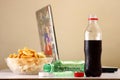 Bottles of softdrinks or soda, chips and a laptop computer in the background Royalty Free Stock Photo