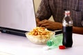 Bottles of softdrinks or soda, chips and man working on a laptop computer in the background Royalty Free Stock Photo