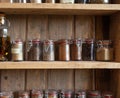 Bottles with spices and seasonings in wooden rack. Various different organic herbs for in the kitchen vintage look Royalty Free Stock Photo